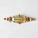 An Edwardian 15ct rose gold bar brooch with seven small diamonds set in a scrolling mount,