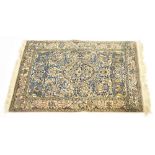 A modern cream ground carpet with blue central medallion within all-over floral decoration within a