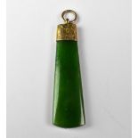 A jade intaglio pendant drop of tapered form, carved with the head of a tribal man,