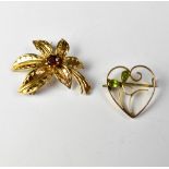 A 9ct gold flower brooch set with red central stone, length approx 4.