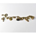 A 9ct gold charm bracelet with approximately eleven gold charms, including Aladdin's lamp, dog,