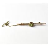 An Edwardian 9ct gold bar brooch with a flower cluster centre comprising cut green stone within a