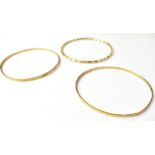 Three 9ct gold bangles, comprising a ropetwist example, and two with bright cut decoration,