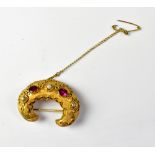 A 19th century gilt or yellow metal crescent-shaped brooch with protruding bezel set red stones,