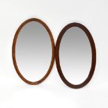 An oak framed oval wall mirror with bevelled plate,