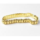 A 14ct gold flat link articulated bracelet with star motifs to the central links, stamped '585',