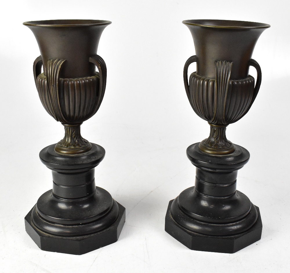 A pair of late 19th century bronze urns, each with flared rim, four ribbed handles, lobed surbase,