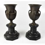 A pair of late 19th century bronze urns, each with flared rim, four ribbed handles, lobed surbase,