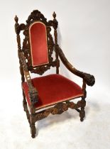 A late 19th century Continental carved oak elbow chair with padded back and seat and grotesque