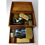 A writing box containing various collectibles, smoking paraphernalia including lighters,