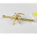 A vintage 15ct gold bar brooch with a central spider set with pale blue gemstone (possibly