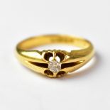 An 18ct gold ring set with central solitaire diamond, within a stylised open claw fitting,