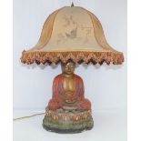 An early 20th century Chinese table lamp in the form of a seated Buddha in front of censer,