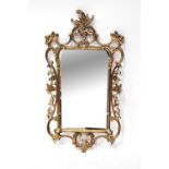 A gilt wall mirror with rectangular plate within pierced and scroll borders, 106 x 57cm.