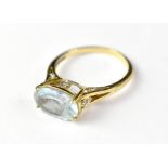 A 9ct gold dress ring with a large oval claw set light blue stone (possibly aquamarine), size Q,