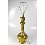 An Eastern brass vase-shaped table lamp, profusely decorated with foliate and floral motifs,