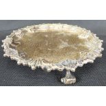 A Victorian hallmarked silver small tray with raised shell border, raised on three scroll feet,