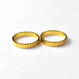 Two identical 18ct gold band rings, with turned decoration,