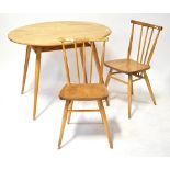 A mid-20th century Ercol-style oval fixed top dining table raised on outswept turned supports with