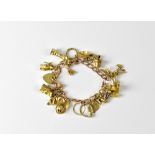 A 9ct gold curb link charm bracelet with seventeen various charms, to include a windmill, church,