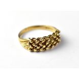 A 9ct gold ring, the top with four lines of open set gold beads, size X, approx 3.7g.