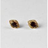 A pair of claw set oval garnet stud earrings in a 9ct gold mount with butterfly fasteners,