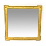 A gilt framed wall mirror with bevelled plate, the frame with beaded and roundel decoration,