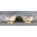 A pair of George V hallmarked silver sauce boats with beaded edge, ring foot and scroll handle,