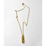 A yellow metal Egyptian pendant with central vertical line of hieroglyphics, Egyptian hallmarks,