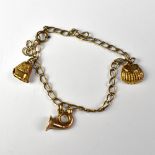 A small 9ct gold charm bracelet with three small charms comprising a fishing creel,