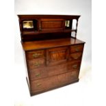 An Edwardian walnut side cabinet with dentil moulded cornice above small panelled door flanked by