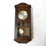 An early 20th century oak cased regulator clock, the silvered dial set with Arabic numerals,