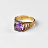 A 9ct gold dress ring with cut amethyst stone and textured shoulders, size J, approx 2.3g.