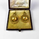 A pair of 19th century yellow gold earrings with suspended bow with internal serrated circle,