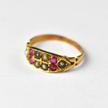 A Victorian 18ct gold ring set with four small rubies and seed pearls, on flower head shoulders,