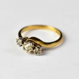 An 18ct gold three-stone diamond ring, the principal diamond approx 0.