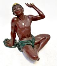 A plaster figural table base posed as a figure sitting cross-legged,