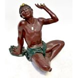 A plaster figural table base posed as a figure sitting cross-legged,
