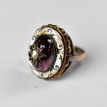 An early 19th century yellow metal ring with protruding cabochon red stone, possibly garnet,