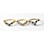 Three 9ct gold wishbone rings, one with five blue stones and four white stones, size O,