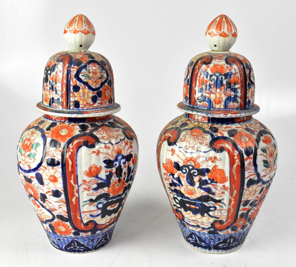 A pair of Japanese Meiji period Imari ribbed vases and covers, height 35cm (2).