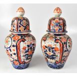 A pair of Japanese Meiji period Imari ribbed vases and covers, height 35cm (2).