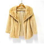 A cream-coloured fur jacket with wide collar, by Ellis Barker Furs of Chester,