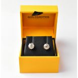 A pair of white metal diamond stud earrings, each in eight-claw basket-style settings,