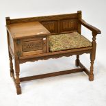 OLD CHARM FURNITURE; an oak telephone seat, with two linenfold panels to the back,