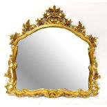 A large Rococo-style gilt framed wall mirror with pierced C-scroll and flower motifs to the frame,