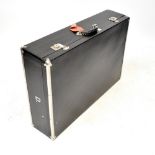 A refurbished vintage black leatherette and metal bound car trunk,