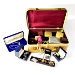 A vintage cream vanity case containing a quantity of mainly vintage costume jewellery,