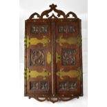 A late 19th century Gothic oak and brass bound hanging two-door cabinet with quatrefoil detail and