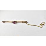 A 9ct gold bar brooch with a bezel set pink stone, with split shoulders, on a split pin brooch,